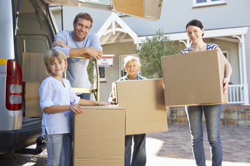 Removalists carrying furniture from a flat near Colliers Wood